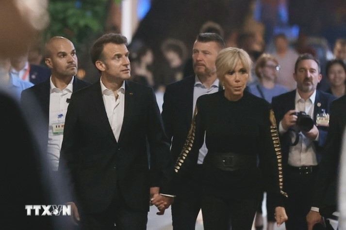 Tổng thống Pháp Emmanuel Macron và Phu nhân nắm tay nhau cùng dạo phố cổ Hà Nội. (Ảnh: TTXVN)
