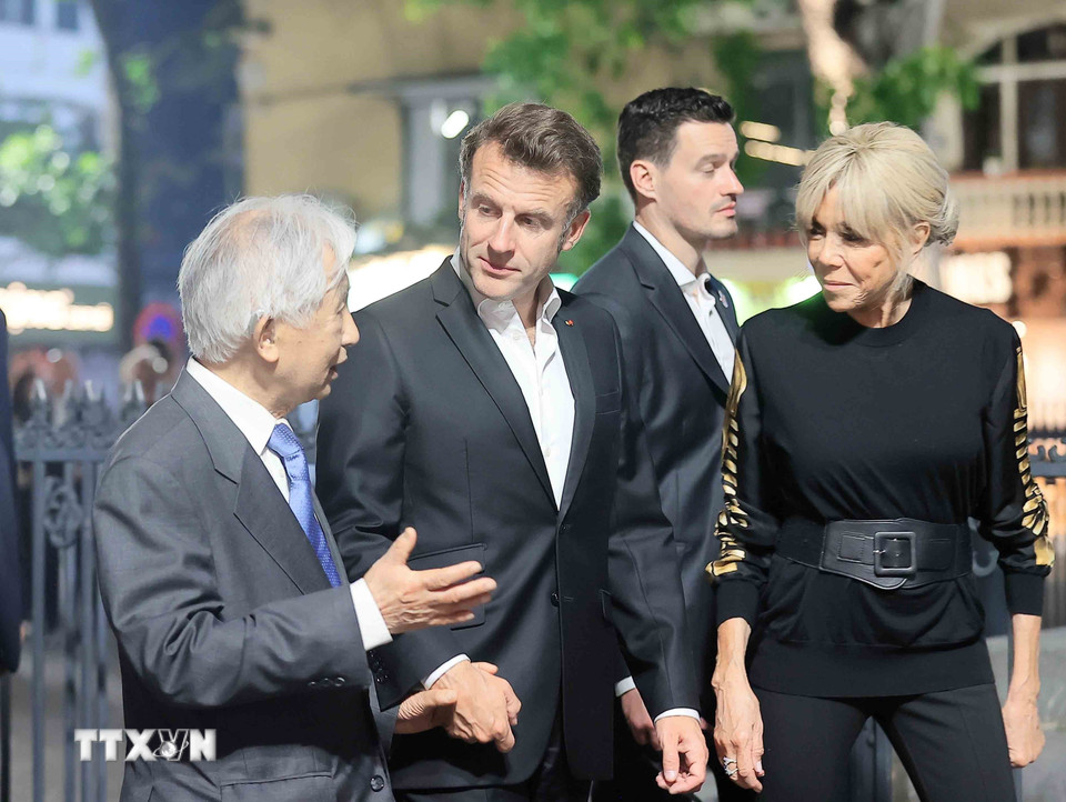 Tổng thống Pháp Emmanuel Macron và Phu nhân nghe giới thiệu về nét văn hóa phố cổ Hà Nội. (Ảnh: TTXVN)