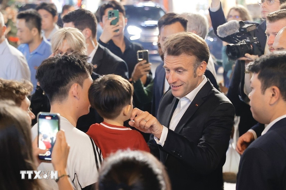 Tổng thống Pháp và Phu nhân gặp gỡ người dân trên đường tản bộ khu vực phố cổ Hà Nội. (Ảnh: TTXVN)