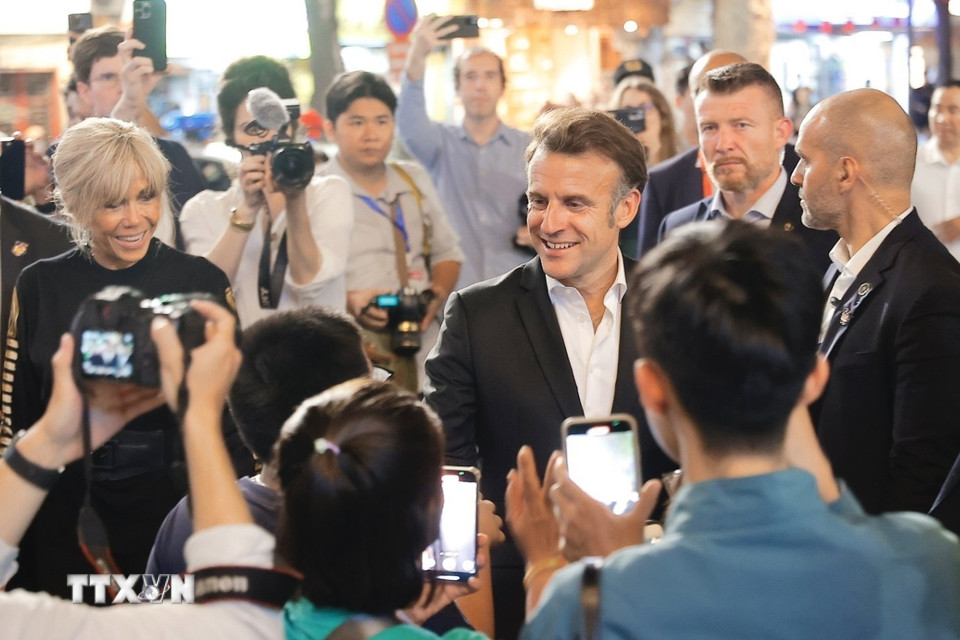 Tổng thống Pháp và Phu nhân gặp gỡ người dân trên đường tản bộ khu vực phố cổ Hà Nội. (Ảnh: TTXVN)