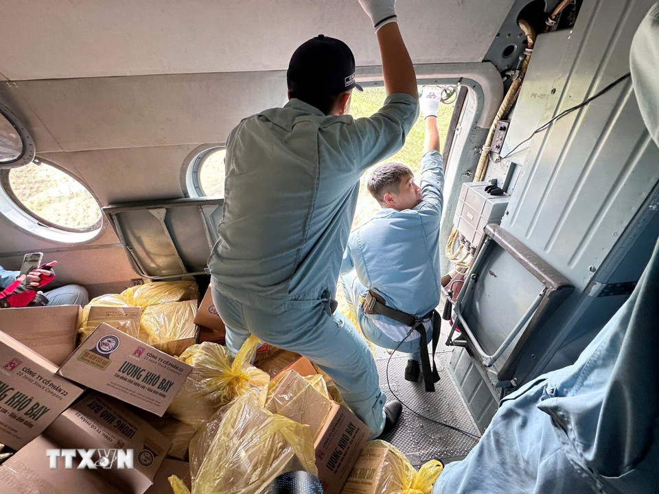 Phi công chuyển hàng hóa từ trực thăng xuống các địa điểm thuộc xã Vân Nham và xã Yên Bình đang bị cô lập vì lũ. (Ảnh: TTXVN phát)