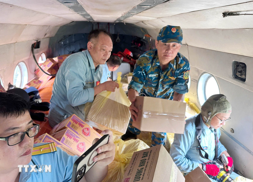 Phi công chuyển hàng hóa từ trực thăng xuống các địa điểm thuộc xã Vân Nham và xã Yên Bình đang bị cô lập vì lũ. (Ảnh: TTXVN phát)