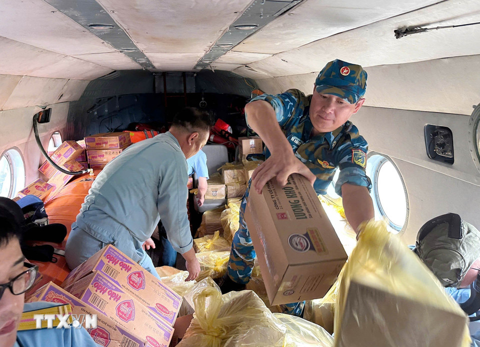 Phi công chuyển hàng hóa từ trực thăng xuống các địa điểm thuộc xã Vân Nham và xã Yên Bình đang bị cô lập vì lũ. (Ảnh: TTXVN phát)