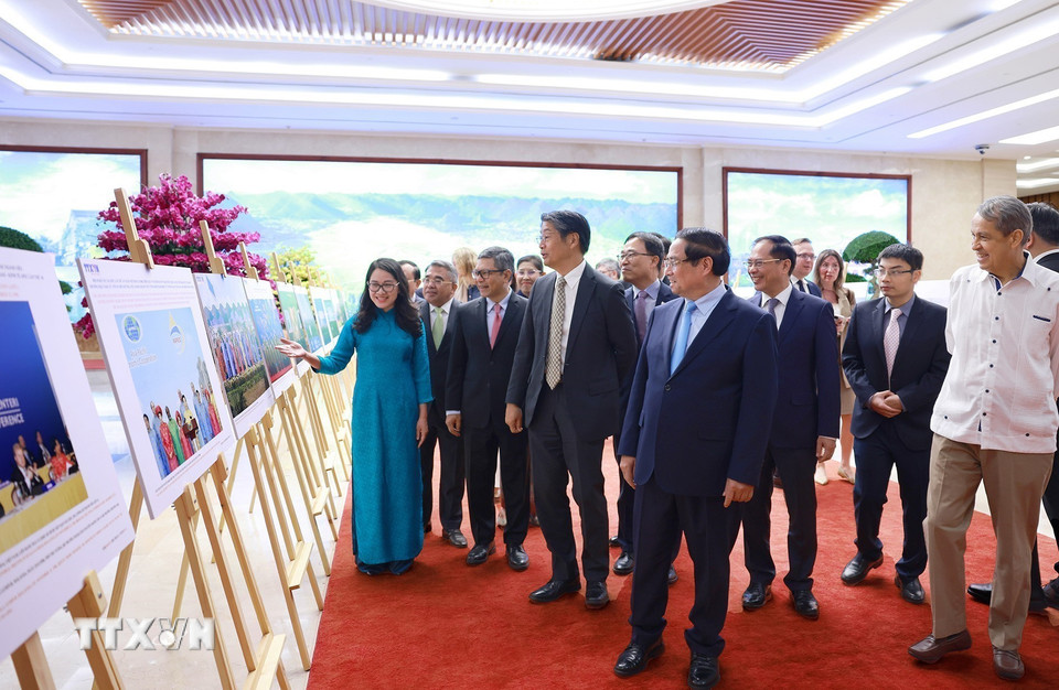 Thủ tướng Phạm Minh Chính và các đại biểu xem trưng bày ảnh về vai trò và những đóng góp tích cực của Việt Nam từ khi gia nhập APEC cùng công tác chuẩn bị APEC 2027. (Ảnh: Dương Giang/TTXVN)