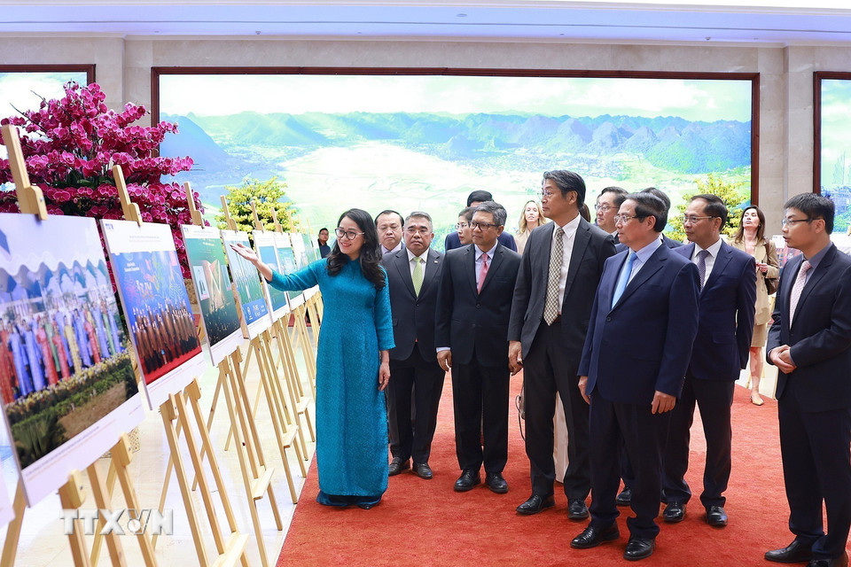 Thủ tướng Phạm Minh Chính và các đại biểu xem trưng bày ảnh về vai trò và những đóng góp tích cực của Việt Nam từ khi gia nhập APEC cùng công tác chuẩn bị APEC 2027. (Ảnh: Dương Giang/TTXVN)