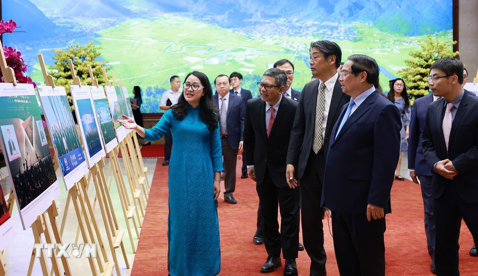 Thủ tướng Phạm Minh Chính và các đại biểu xem trưng bày ảnh về vai trò và những đóng góp tích cực của Việt Nam từ khi gia nhập APEC cùng công tác chuẩn bị APEC 2027. (Ảnh: Dương Giang/TTXVN)