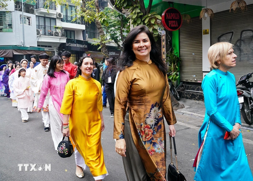 Một người nước ngoài mặc trang phục áo dài Việt Nam đi trong đoàn diễu hành. (Ảnh: Khánh Hòa/TTXVN)