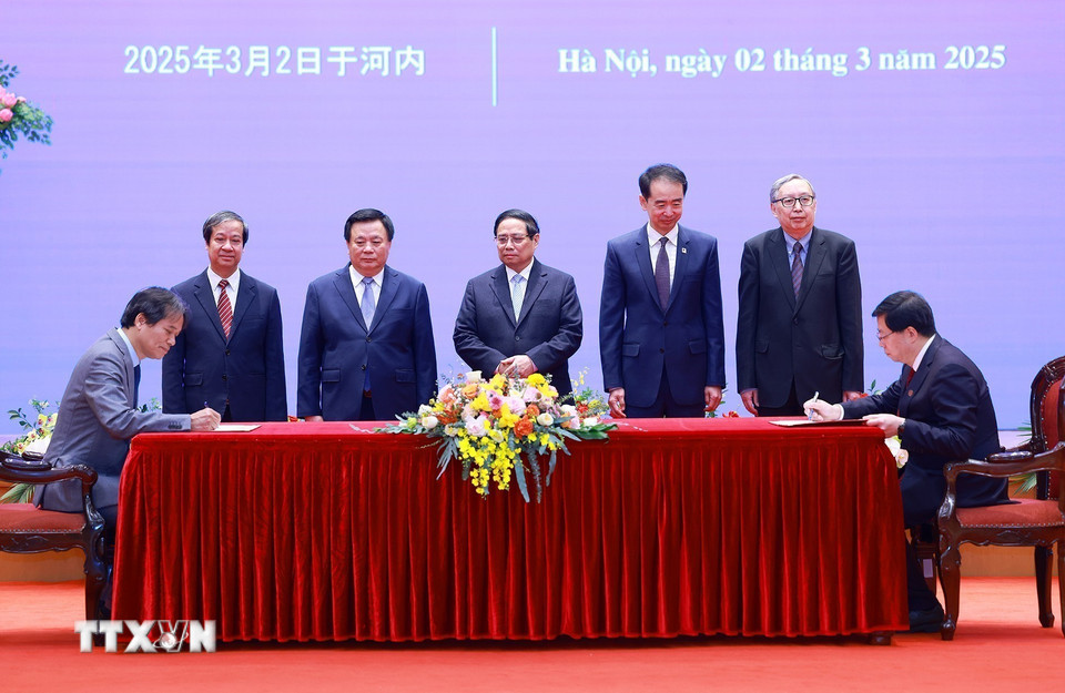 Thủ tướng Phạm Minh Chính chứng kiến ký văn kiện hợp tác giáo dục giữa Đại học Kinh tế Quốc dân và Đại học Thanh Hoa, Trung Quốc. (Ảnh: Dương Giang/TTXVN)