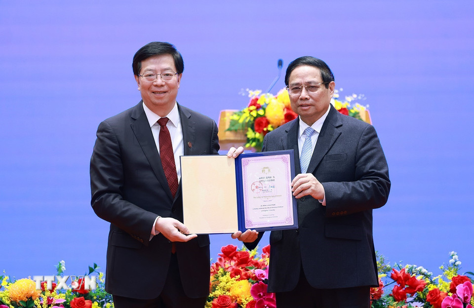 Đồng chí Khưu Dũng, Bí thư Đảng ủy Đại học Thanh Hoa, Trung Quốc trao tặng Thủ tướng Phạm Minh Chính danh hiệu "Giáo sư danh dự Đại học Thanh Hoa". (Ảnh: Dương Giang/TTXVN)