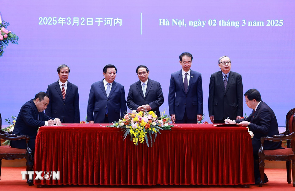 Thủ tướng Phạm Minh Chính chứng kiến ký văn kiện hợp tác giáo dục giữa Đại học Quốc gia Thành phố Hồ Chí Minh và Đại học Thanh Hoa, Trung Quốc. (Ảnh: Dương Giang/TTXVN)