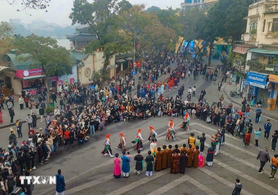 Đoàn rước lễ tại không gian đi bộ hồ Hoàn Kiếm thu hút sự quan tâm của nhân dân và du khách. (Ảnh: Thanh Tùng/TTXVN)