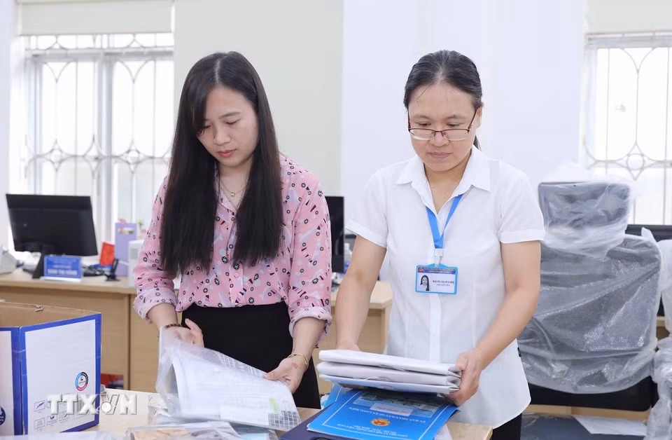 Nhân viên phường Long Biên hoàn tất việc chỉnh trang trụ sở, sẵn sàng cho lễ công bố vận hành chính quyền 2 cấp. (Ảnh: Thành Phuơng/TTXVN)