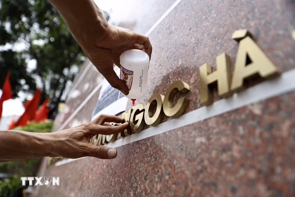 Công nhân đơn vị thi công gắn biển trụ sở phường Ngọc Hà, thành phố Hà Nội. (Ảnh: Lê Đông/TTXVN)