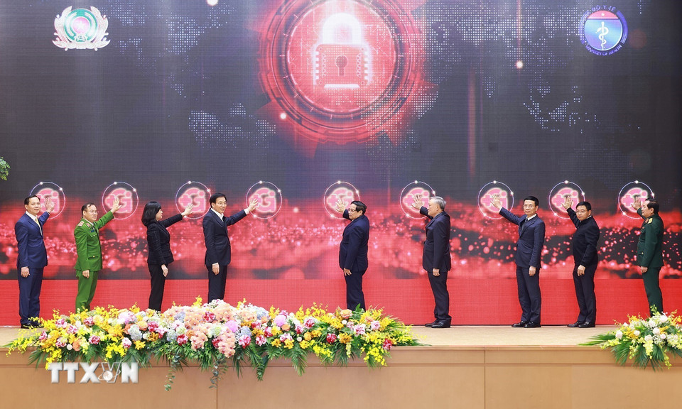 Thủ tướng Phạm Minh Chính và các đại biểu bấm nút khai trương hệ thống điều phối dữ liệu ngành y tế. (Ảnh: Dương Giang/TTXVN)