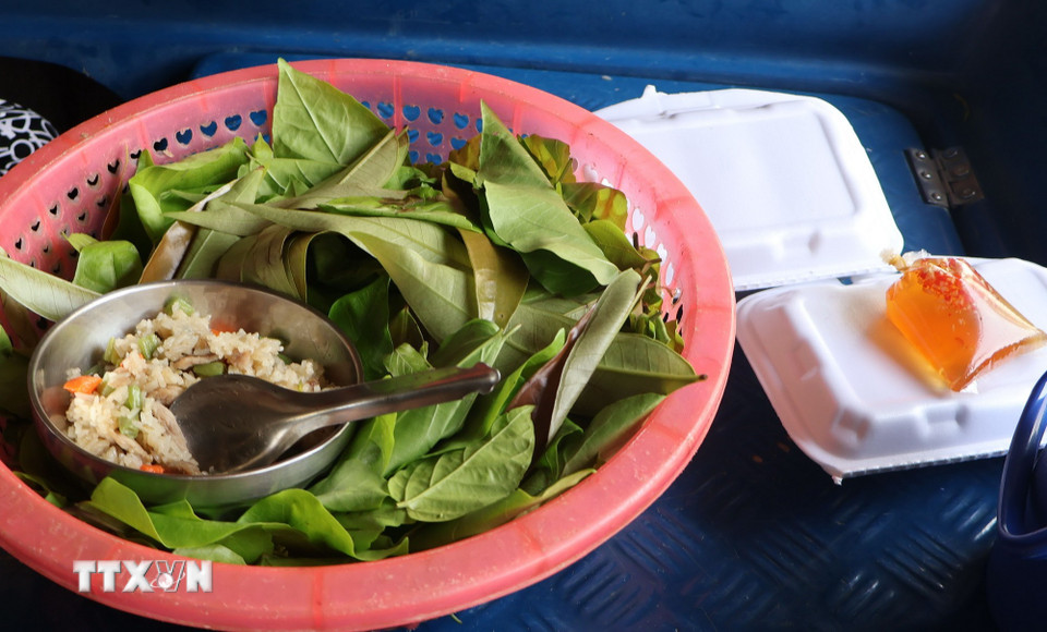 Bữa cơm của học sinh đi học bằng xuồng ghe. (Ảnh: Tuấn Phi/TTXVN)