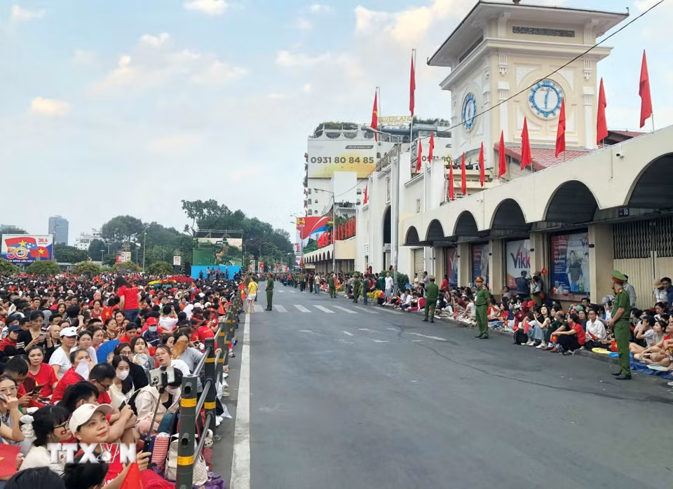 Khu vực chợ Bến Thành, người dân đến rất sớm để đón đoàn diễu binh, diễu hành đi ngang qua. (Ảnh: Thu Hương/TTXVN)