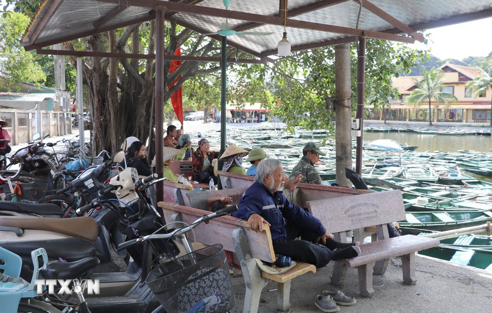 Lái đò Khu du lịch Tam Cốc-Bích Động, thành phố Hoa Lư, tỉnh Ninh Bình tranh thủ lúc vắng khách tránh nắng ở những khu vực có bóng mát. (Ảnh: Thùy Dung/TTXVN)