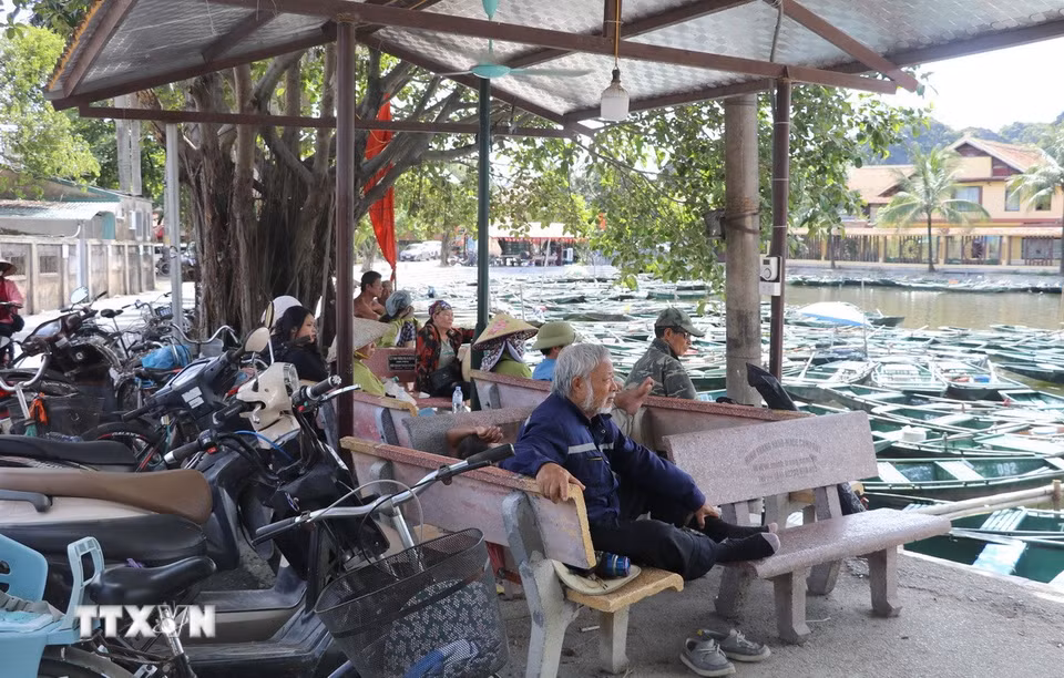Lái đò Khu du lịch Tam Cốc-Bích Động, thành phố Hoa Lư, tỉnh Ninh Bình tranh thủ lúc vắng khách tránh nắng ở những khu vực có bóng mát. (Ảnh: Thùy Dung/TTXVN)
