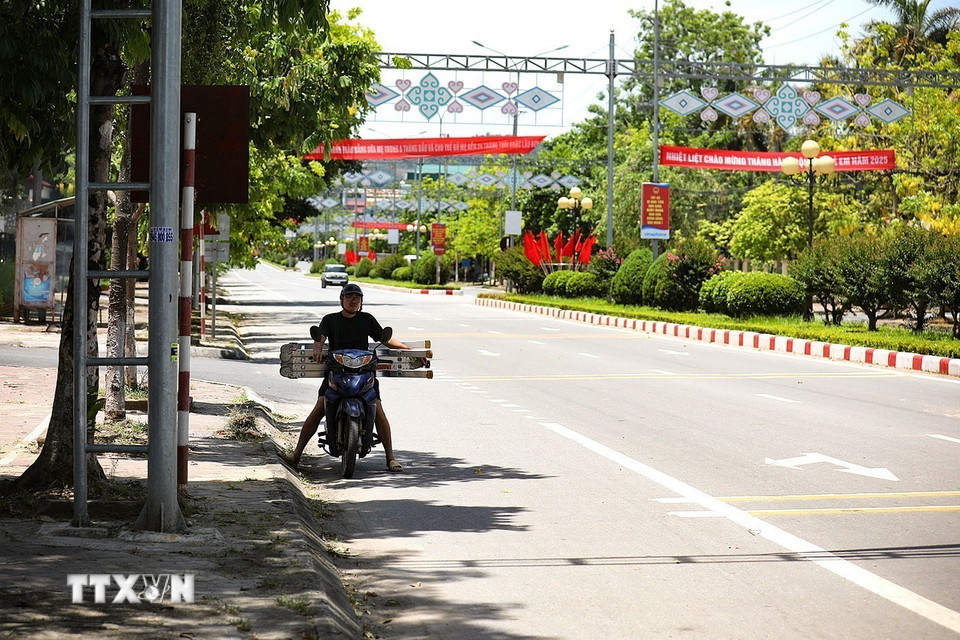 Người dân dừng xe tránh nắng dưới bóng cây chờ đèn đỏ trên Đại lộ Thịnh Lang, thành phố Hòa Bình. (Ảnh: Trọng Đạt/TTXVN)