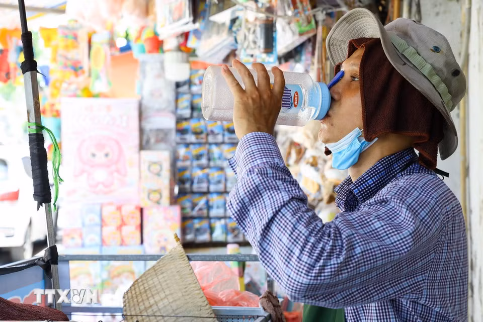 Nắng nóng gay gắt, nhiều lao động tại Hà Nội phải tìm cách thích nghi để tiếp tục mưu sinh. (Ảnh: Lê Đông/TTXVN)