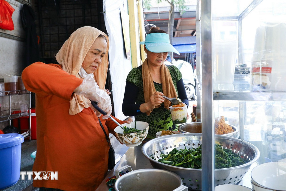 Quán ăn khu vực chợ Đồng Xuân, Hà Nội tất bật phục vụ khách giữa trời nắng nóng. (Ảnh: Lê Đông/TTXVN)