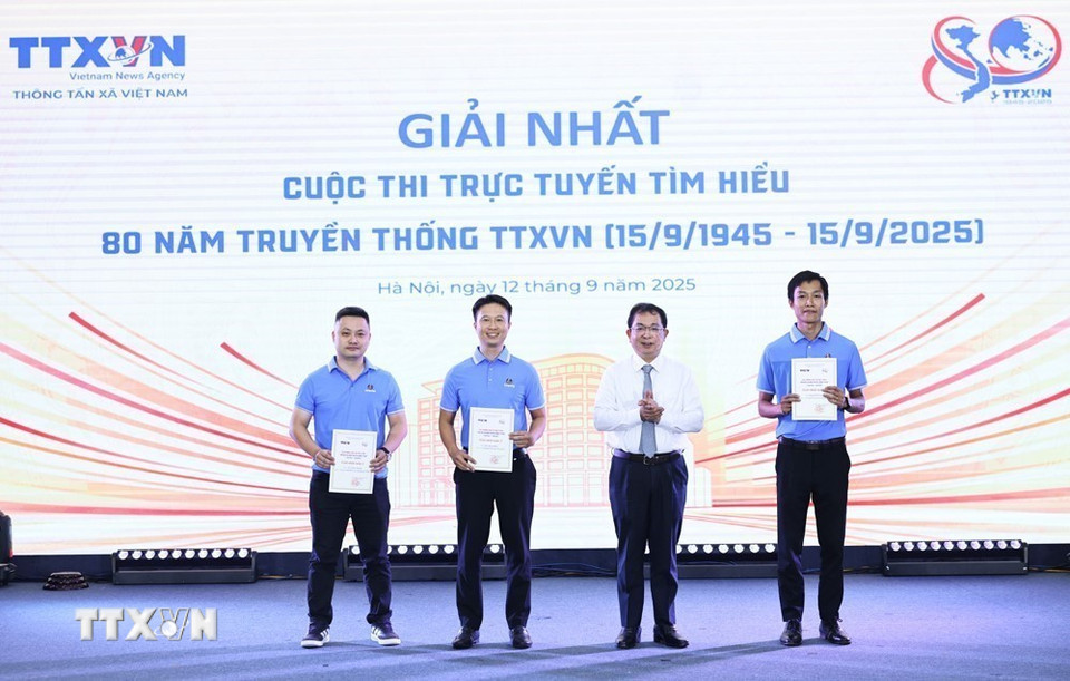 Đồng chí Nguyễn Tuấn Hùng, Phó Bí thư thường trực Đảng ủy, Phó Tổng giám đốc, Phó Chủ tịch Hội đồng thi đua khen thưởng của TTXVN trao giải Nhất cho các tác giả cuộc thi trực tuyến tìm hiểu 80 năm truyền thống TTXVN. (Ảnh: Minh Đức/TTXVN)