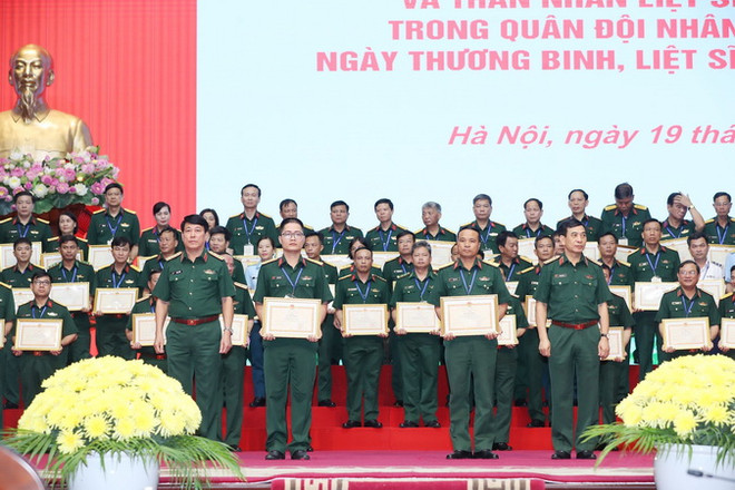 Đại tướng Phan Văn Giang, Bộ trưởng Quốc phòng; Đại tướng Lương Cường, Chủ nhiệm Tổng cục Chính trị Quân đội Nhân dân Việt Nam trao Bằng khen của Bộ trưởng Bộ Quốc phòng cho các cá nhân. (Ảnh: Trọng Đức/TTXVN) Gặp mặt người có công, thân nhân liệt sỹ đang công tác trong Quân đội ảnh 1