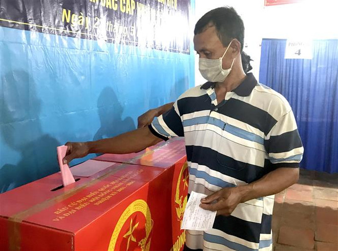 Cử tri ấp Kỳ Son, xã Loan Mỹ, huyện Tam Bình, tỉnh Vĩnh Long bỏ phiếu vào thùng phiếu bầu. (Ảnh: Lê Thúy Hằng/TTXVN) Ngày Bầu cử đã diễn ra an toàn, dân chủ, đúng quy định ảnh 4