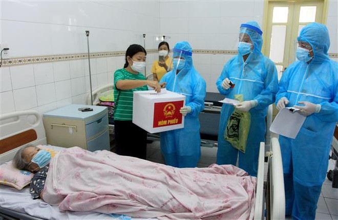 Hòm phiếu phụ được đưa đến 5 khoa thuộc diện phong tỏa tại Bệnh viện đa khoa tỉnh Thái Bình để bệnh nhân và người nhà bệnh nhân tại đây thực hiện quyền công dân của mình. (Ảnh: Thế Duyệt/TTXVN) Ngày Bầu cử đã diễn ra an toàn, dân chủ, đúng quy định ảnh 2
