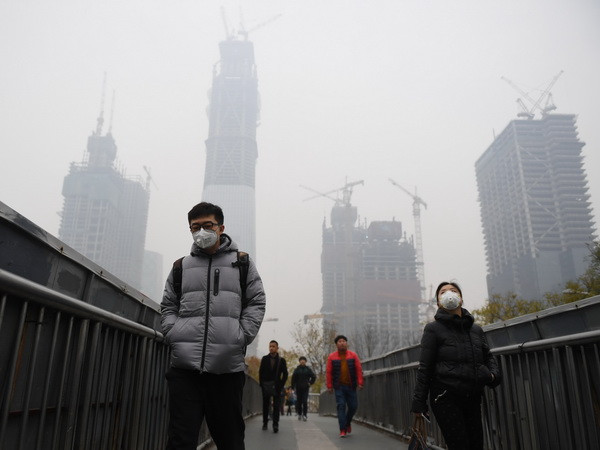 Khói mù bao phủ thủ đô Bắc Kinh, Trung Quốc ngày 18/11 vừa qua. (Ảnh: AFP/TTXVN) Thủ đô Bắc Kinh ban hành cảnh báo đỏ về ô nhiễm không khí ảnh 1
