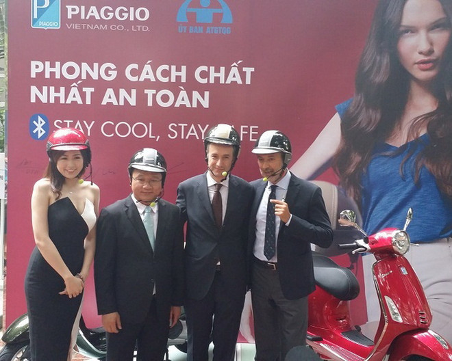 Ông Khuất Việt Hùng, Phó Chủ tịch Ủy Ban An toàn giao thông quốc gia (thứ 2 bên trái) cùng lãnh đạo Piaggio dùng thử mũ bảo hiểm tích hợp bluetooth. (Nguồn: Piaggio Việt Nam ra mắt mũ bảo hiểm gắn tai nghe không dây ảnh 1