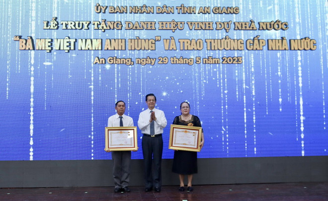 Thừa ủy quyền của Chủ tịch nước, ông Lê Hồng Quang, Bí thư Tỉnh ủy An Giang trao Bằng vinh dự truy tặng Danh hiệu “Bà mẹ Việt Nam Anh hùng” cho thân nhân mẹ Lâm Thị Chính và mẹ Mai Thị Măng. (Ảnh: Thanh Sang/TTXVN) An Giang: Lễ truy tặng danh hiệu Bà mẹ Việt Nam Anh hùng ảnh 1