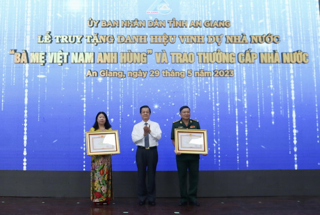 Ông Lê Hồng Quang, Bí thư Tỉnh ủy An Giang trao trao Bằng khen của Thủ tướng Chính phủ cho các tập thể, cá nhân có thành tích trong công tác phân giới cắm mốc trên đất liền Việt Nam-Campuchia từ năm 1999 đến 2019. (Ảnh: Thanh Sang/TTXVN) An Giang: Lễ truy tặng danh hiệu Bà mẹ Việt Nam Anh hùng ảnh 2