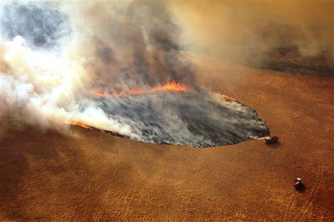 Khói lửa bốc lên từ đám cháy rừng ở bang Victoria, Australia. (Ảnh: AFP/TTXVN) Thế giới thiệt hại 600.000 tỷ USD nếu chống biến đổi khí hậu thất bại ảnh 1