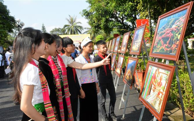 Các em học sinh tham quan Triển lãm. (Ảnh: Tuấn Anh/TTXVN) Nét đẹp của di sản Nghệ thuật Xòe Thái qua các bức ảnh ảnh 1