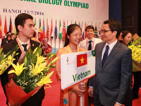 Phó Thủ tướng Vũ Đức Đam tặng hoa chúc mừng thành tích của thí sinh đoàn Việt Nam. (Ảnh: Quý Trung/TTXVN) Trao 26 huy chương vàng cho thí sinh thi Olympic Sinh học ảnh 1