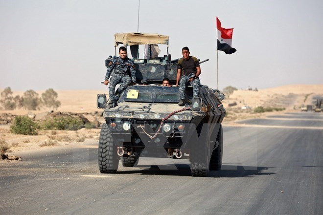 Binh sỹ Iraq trong chiến dịch truy quét IS tại Mosul ngày 31/10. (Nguồn: EPA/TTXVN) Quốc kỳ Iraq bay trên thành cổ Nimrud sau trận kịch chiến với quân IS ảnh 2