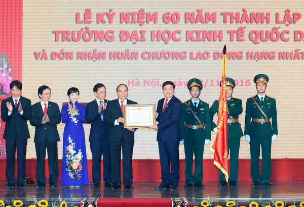 Thủ tướng Nguyễn Xuân Phúc trao tặng Huân chương Lao động hạng Nhất của Chủ tịch nước cho Trường Đại học Kinh tế Quốc dân. (Ảnh: Thống Nhất/TTXVN) Để Đại học Kinh tế quốc dân đi đầu trong hệ sinh thái khởi nghiệp ảnh 1
