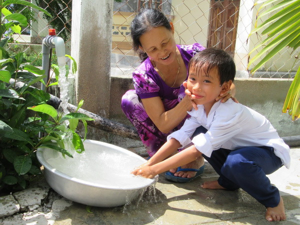 Người dân sử dụng nước sạch từ dự án. (Ảnh: Nguyễn Thành/TTXVN) Ninh Thuận triển khai cấp nước sạch cho hơn 1.000 hộ dân vùng hạn mặn ảnh 1