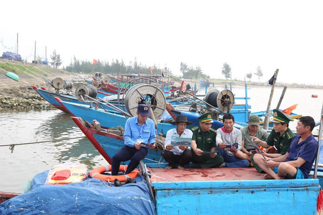 Bộ đội Biên phòng tỉnh Hà Tĩnh tuyên truyền cho ngư dân về phòng chống khai thác bất hợp pháp, không báo cáo và không theo quy định. (Ảnh: TTXVN phát) ttxvn_tau ca ha tinh.jpg