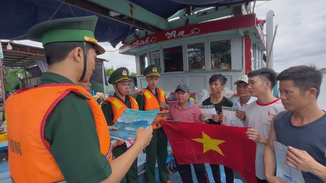 Bộ đội Biên phòng tặng cờ tổ quốc, tuyên truyền pháp luật cho ngư dân. (Ảnh: Đinh Hương/TTXVN) ttxvn_go IUU Quang Ngai.jpg