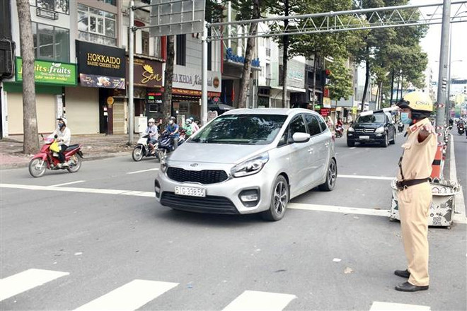 Các chiến sỹ Cảnh sát giao thông TP. HCM tiến hành phân luồng điều tiết giao thông. (Ảnh: Hồng Giang/TTXVN) 5 tình huống giải quyết ùn tắc tại cửa ngõ TP.HCM dịp nghỉ lễ 30/4 ảnh 1