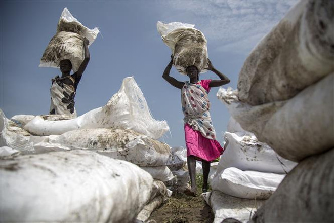 Người dân nhận lương thực cứu trợ tại Jonglei, Nam Sudan. (Ảnh: AFP/TTXVN) WFP: Mất an ninh lương thực có thể trầm trọng thêm do COVID-19 ảnh 1