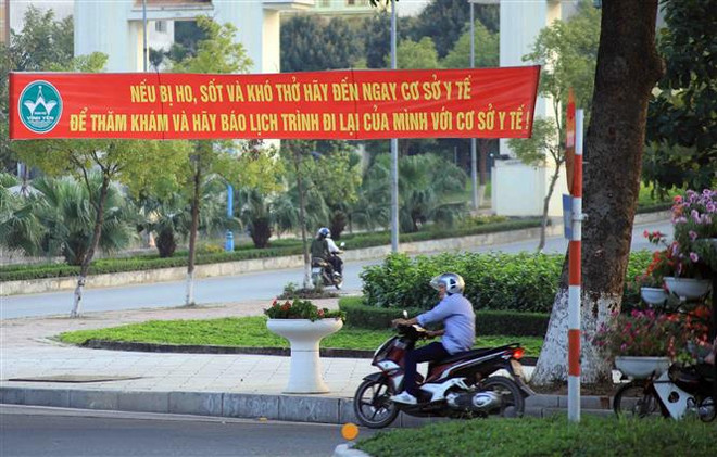 Băngrôn tuyên truyền, hướng dẫn người dân phòng, chống dịch COVID-19 trên đường Mê Linh, thành phố Vĩnh Yên. (Ảnh: Hoàng Hùng/TTXVN) Truyền thông Đức: Việt Nam là điểm sáng trong cuộc chiến chống COVID ảnh 2