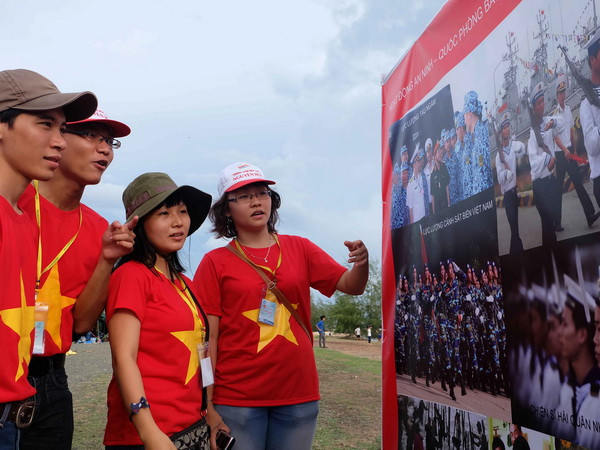 Sinh viên xem ảnh tại triển lãm ảnh “Tự hào biển đảo Việt Nam.” (Ảnh: Đoàn Bắc/TTXVN phát) Bế mạc chương trình "Sinh viên với biển đảo Tổ quốc năm 2014" ảnh 1