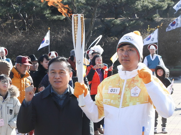Rước ngọn đuốc Thế vận hội Mùa đông PyeongChang 2018 qua thành phố Cheonan, Hàn Quốc, ngày 17/12. (Ảnh: Yonhap/TTXVN) Hàn Quốc và IOC thuyết phục Triều Tiên tham gia TVH mùa Đông 2018 ảnh 1