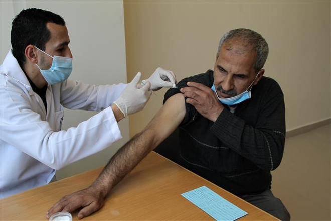 Nhân viên y tế tiêm vaccine ngừa COVID-19 cho người dân Palestine tại Dải Gaza. (Ảnh: THX/TTXVN) Israel phải chăm lo sức khỏe người dân Palestine ở vùng chiếm đóng ảnh 1