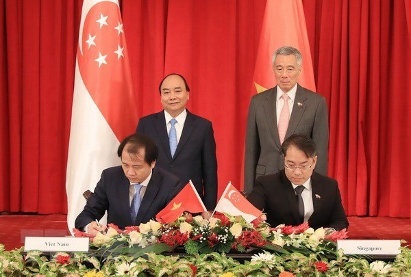 Thủ tướng Nguyễn Xuân Phúc và Thủ tướng Singapore Lý Hiển Long chứng kiến lễ ký kết văn kiện hợp tác giữa hai nước. (Ảnh: Thống Nhất/TTXVN) Tuyên bố chung về quan hệ đối tác chiến lược Việt Nam-Singapore ảnh 3