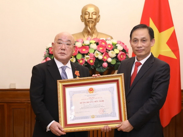Thứ trưởng Bộ Ngoại giao Lê Hoài Trung trao Huân chương Hữu nghị cho Cố vấn đặc biệt Nội các Thủ tướng Nhật Bản Iijima Isao. (Ảnh: Văn Điệp/TTXVN) Trao Huân chương Hữu nghị tặng Cố vấn đặc biệt của Thủ tướng Nhật Bản ảnh 1