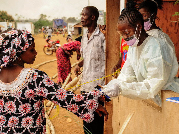 Nhân viên y tế Sierra Leone kiểm tra thân nhiệt của hành khách tại khu vực biên giới với Liberia ở Jendema. (Nguồn: AFP/TTXVN) Virus Ebola có thể lây nhiễm mà không biểu hiện triệu chứng bên ngoài ảnh 1